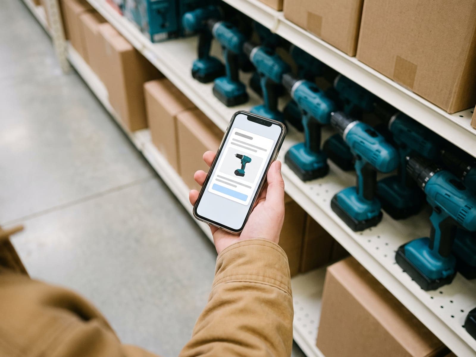 A shopper in a hardware aisle holds up a phone showing an AI answer that recommends one cordless drill.